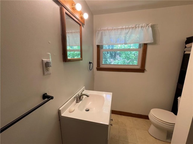 bathroom featuring vanity, toilet, baseboards, and tile patterned floors