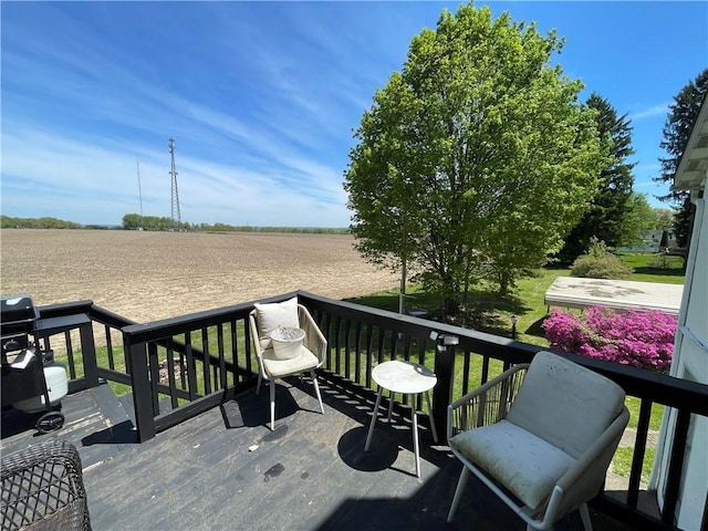 wooden deck with a rural view and agricultural area