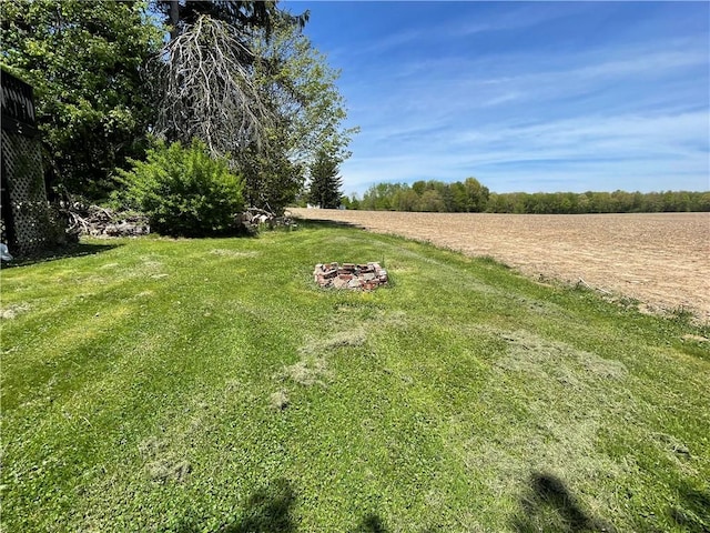 view of grassy yard with a fire pit