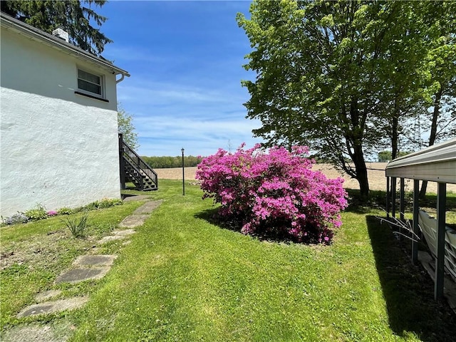view of grassy yard featuring stairs