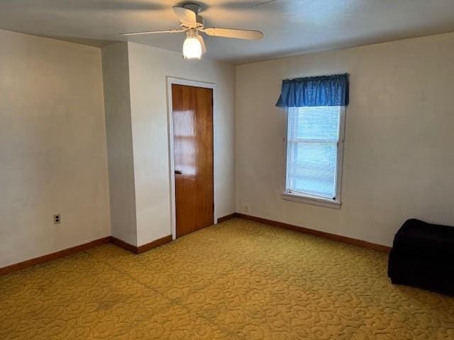 unfurnished room featuring light colored carpet, ceiling fan, and baseboards