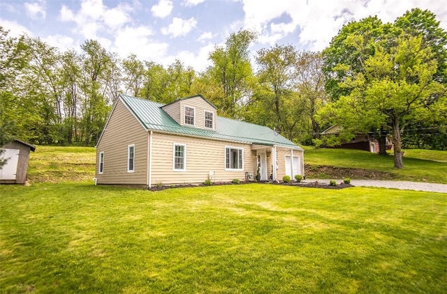 1435 Orchard St, New Sewickley Twp, PA 15042 - view of front facade featuring a front yard, a storage shed, metal roof, an attached garage, and view of wooded area