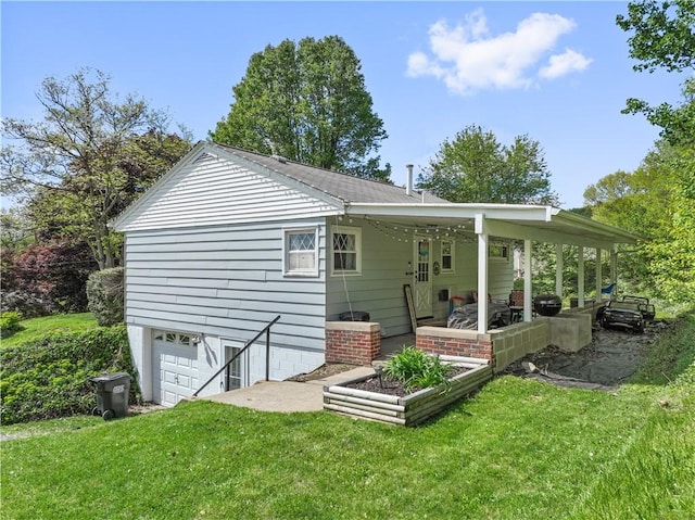 back of property with a lawn and a garage