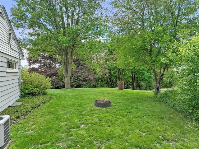 view of grassy yard with central AC