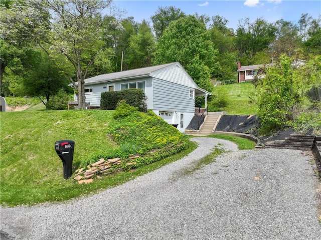 view of front of property featuring driveway, a garage, and a front lawn