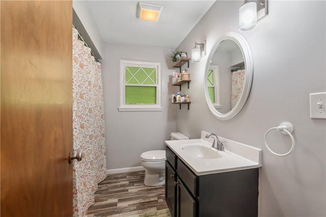 full bathroom with wood finished floors, toilet, vanity, and baseboards