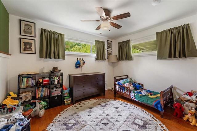 bedroom featuring multiple windows, wood finished floors, and ceiling fan