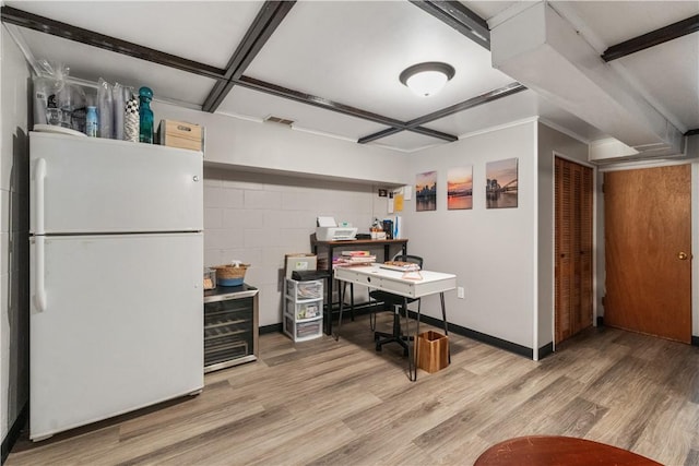 home office featuring light wood-style flooring, concrete block wall, and baseboards