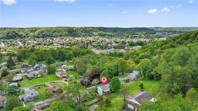 view of property location featuring a heavily wooded area and nearby suburban area