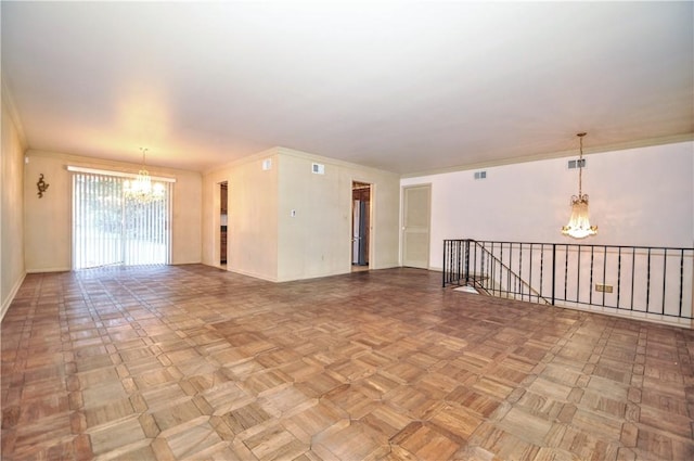 spare room featuring a chandelier, baseboards, and ornamental molding