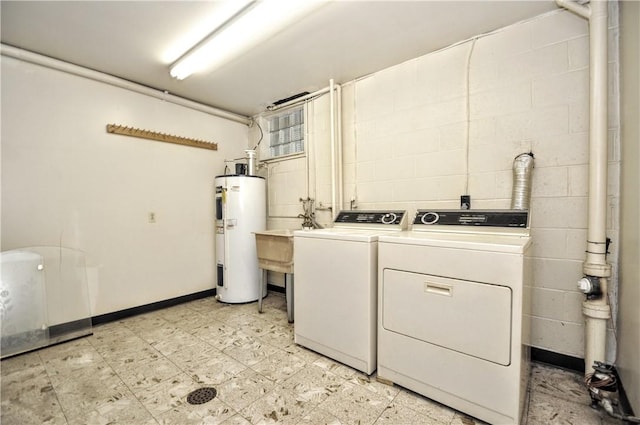 washroom featuring electric water heater, independent washer and dryer, and concrete block wall