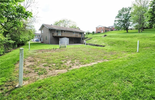 view of grassy yard featuring a garage and a wooden deck