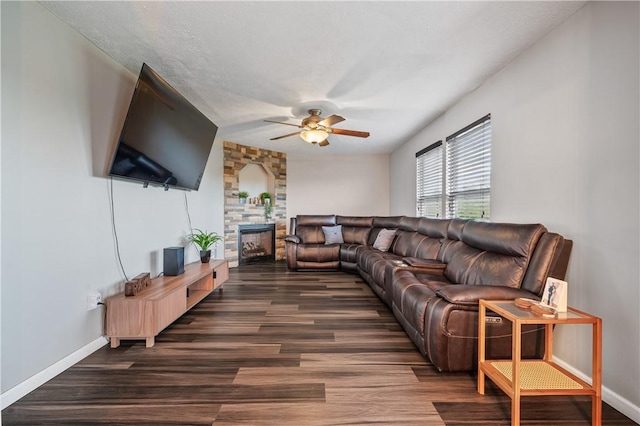 living room featuring a ceiling fan, a fireplace, wood finished floors, and baseboards
