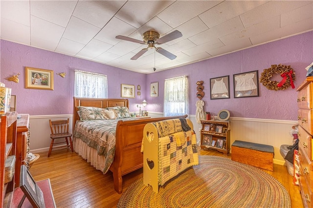 135 Oak Forest Rd, New Freeport, PA 15316 - bedroom with wood-type flooring, a textured wall, a wainscoted wall, and a ceiling fan