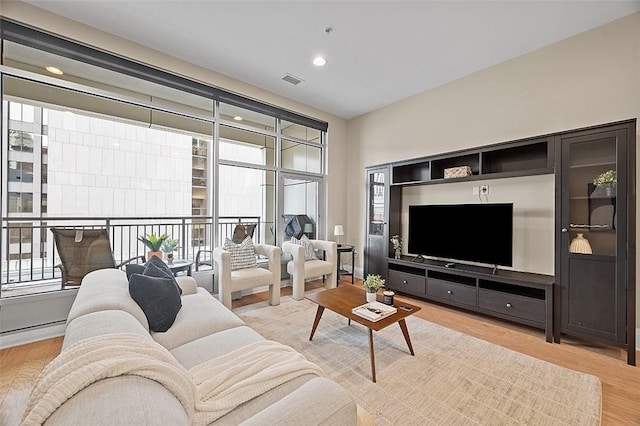 living area with light wood-style flooring and recessed lighting