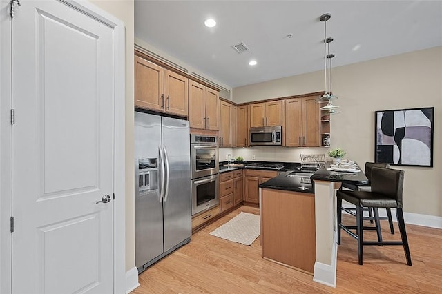 kitchen with appliances with stainless steel finishes, light wood-style floors, open shelves, a breakfast bar area, and a peninsula
