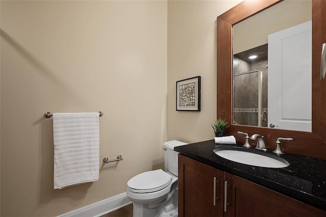 full bath with toilet, vanity, a shower with shower door, and baseboards