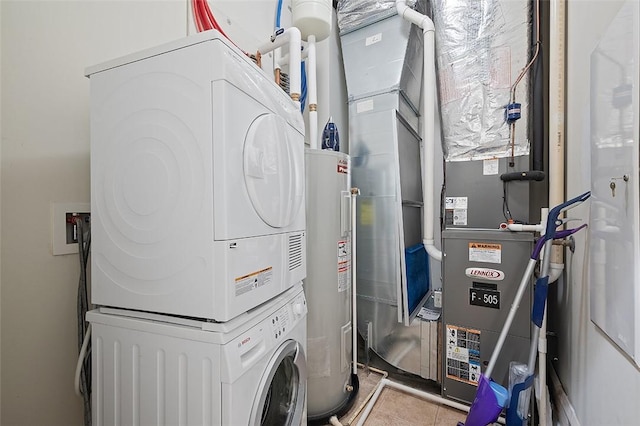 laundry area with stacked washer / drying machine, electric water heater, and tile patterned floors