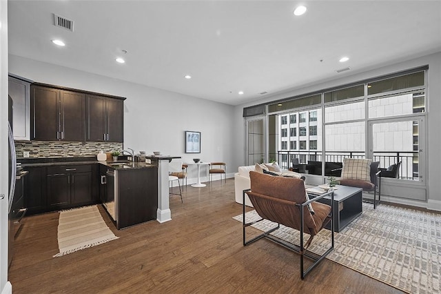 living room with dark wood-style flooring, recessed lighting, and baseboards