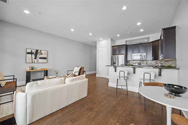 living room featuring recessed lighting, baseboards, and dark wood-style flooring