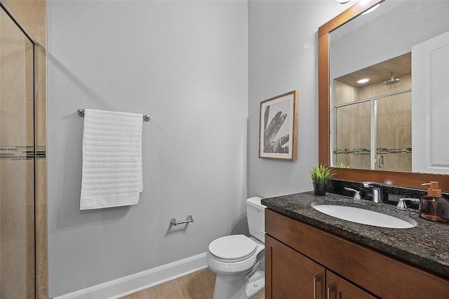 bathroom featuring a stall shower, baseboards, toilet, and vanity