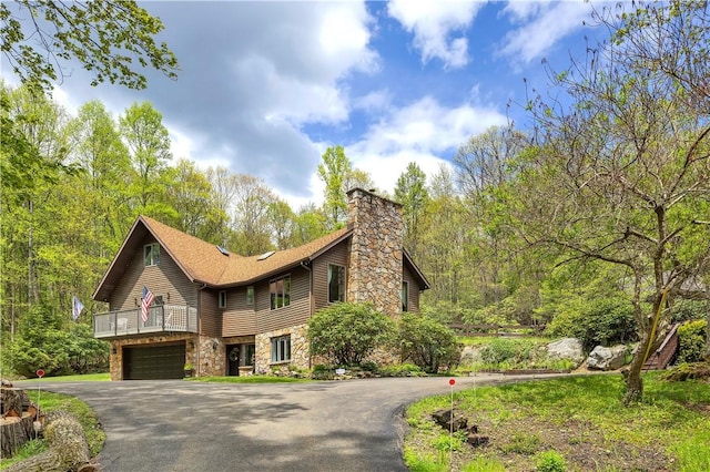 2847 National Pike, Wharton Twp, PA 15421 - view of front of house with stone siding, driveway, a chimney, a garage, and a balcony