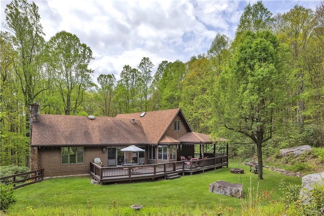 2847 National Pike, Wharton Twp, PA 15421 - rear view of property with an outdoor fire pit, a wooden deck, a chimney, a forest view, and a shingled roof