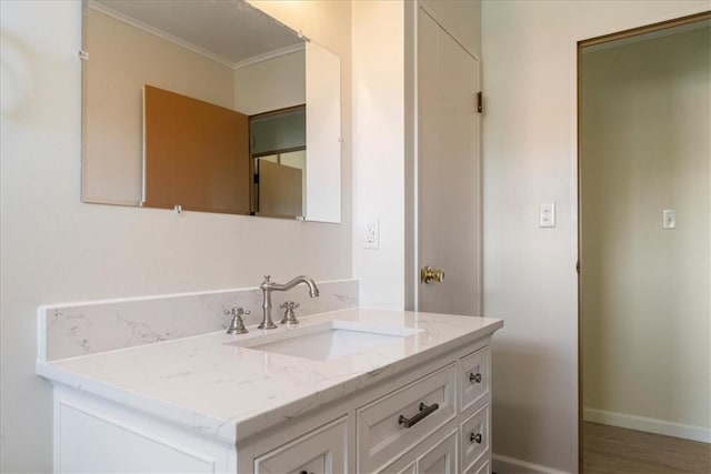 bathroom featuring crown molding, vanity, and baseboards