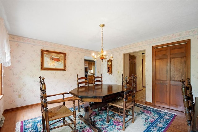 297 Alamae Lakes Rd, South Franklin, PA 15301 - dining area featuring wallpapered walls, light wood-type flooring, a chandelier, and baseboards