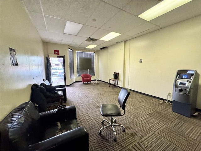 carpeted home office with a paneled ceiling and baseboards