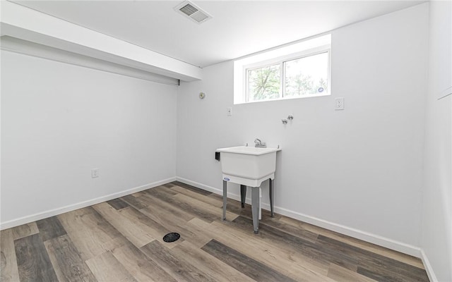 laundry room featuring wood finished floors and baseboards