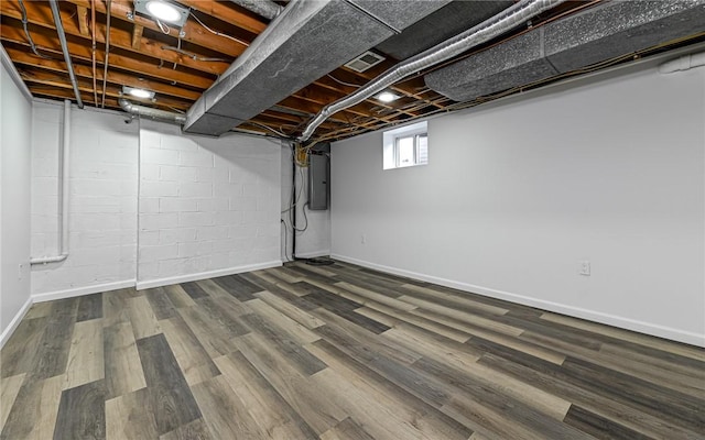 basement featuring electric panel, wood finished floors, and baseboards
