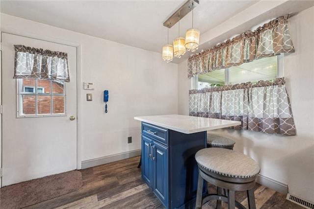 dining space featuring dark wood-style flooring, baseboards, and a chandelier