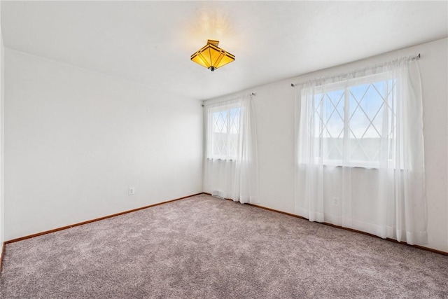 carpeted empty room with baseboards