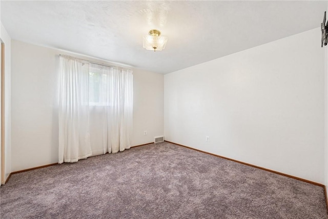 carpeted spare room featuring baseboards