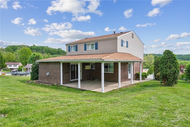 back of property featuring a patio, a lawn, and brick siding