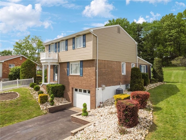 view of home's exterior with a balcony, a garage, asphalt driveway, cooling unit, and brick siding