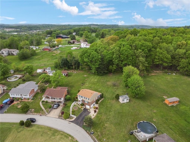 aerial view of property's location with a heavily wooded area and nearby suburban area