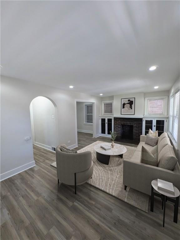 1216 Morrow St, Wilkinsburg, PA 15221 - living room with arched walkways, baseboards, recessed lighting, wood finished floors, and a brick fireplace
