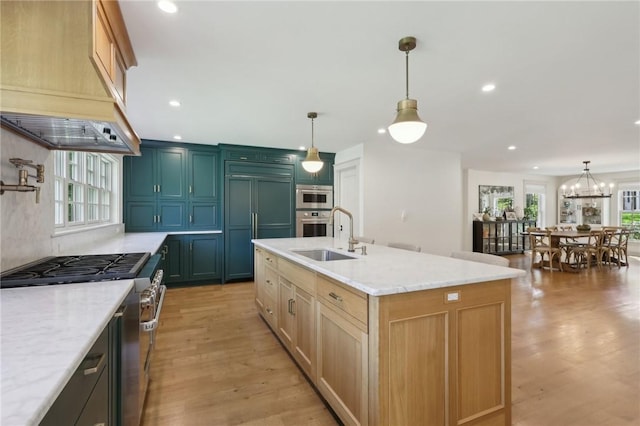 kitchen featuring a sink, premium appliances, light wood-type flooring, recessed lighting, and light stone countertops