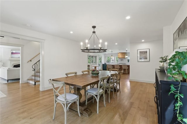 dining room with light wood-style floors, a chandelier, stairs, recessed lighting, and baseboards
