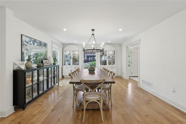 dining area with a chandelier, light wood-style floors, recessed lighting, and baseboards