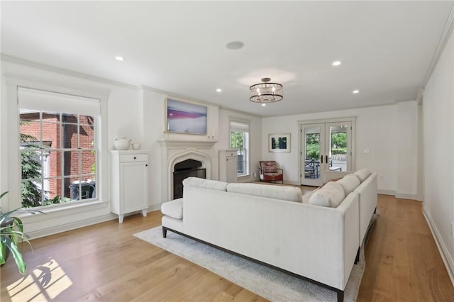 living area featuring light wood-type flooring, a fireplace, recessed lighting, baseboards, and a chandelier