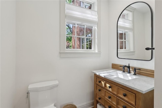 bathroom with vanity, toilet, and baseboards