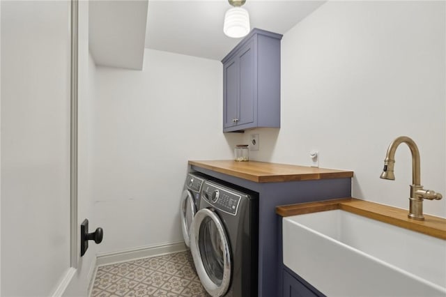 laundry room with washing machine and clothes dryer, cabinet space, and baseboards
