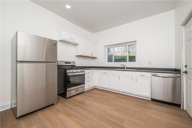 61 Greenbush St, Mt Washington, PA 15211 - kitchen featuring stainless steel appliances, dark countertops, light wood-style floors, white cabinetry, and recessed lighting