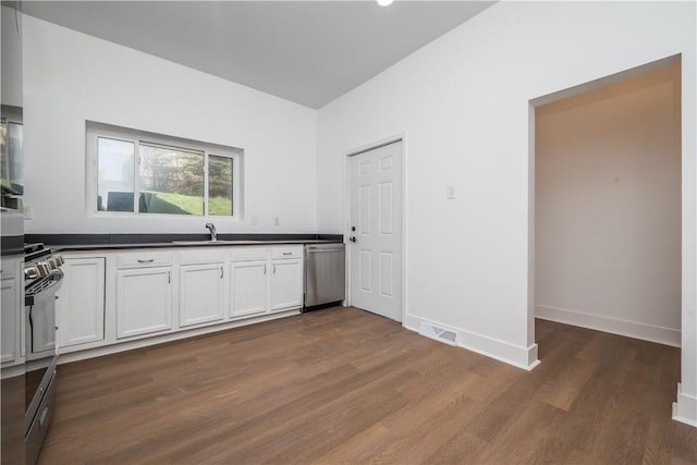 61 Greenbush St, Mt Washington, PA 15211 - kitchen with stainless steel dishwasher, gas stove, dark countertops, dark wood-style floors, and white cabinets