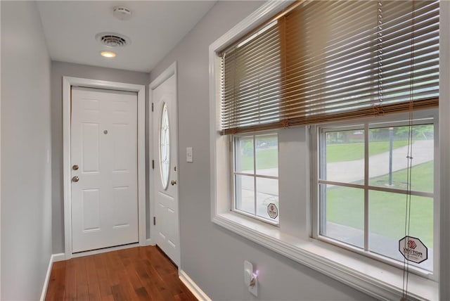 doorway with baseboards and wood finished floors