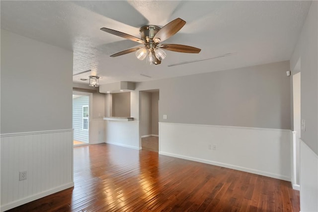 spare room featuring wood-type flooring, a ceiling fan, and baseboards