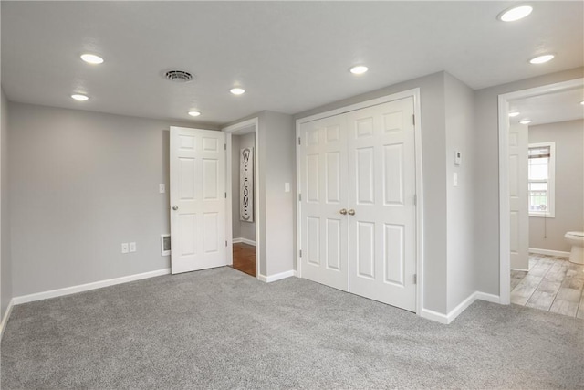 unfurnished bedroom with carpet, recessed lighting, baseboards, and a closet